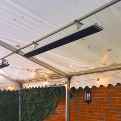 A yandiya 'Zero' model outdoor power heater installed on the top metal railing of a large marquee